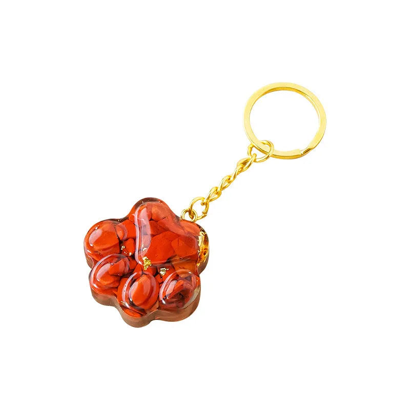 Small crystal cat's paw keychain pendant on a keyring, shown in various gemstone colour options.