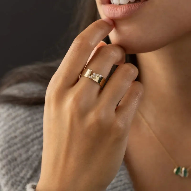 Gold coloured women's ring with a shining zircon stone on a copper band.