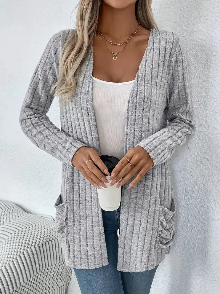 A solid colour long sleeve cardigan with pockets, shown in loose fit on a model.