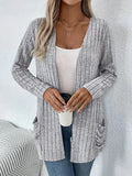 A solid colour long sleeve cardigan with pockets, shown in loose fit on a model.