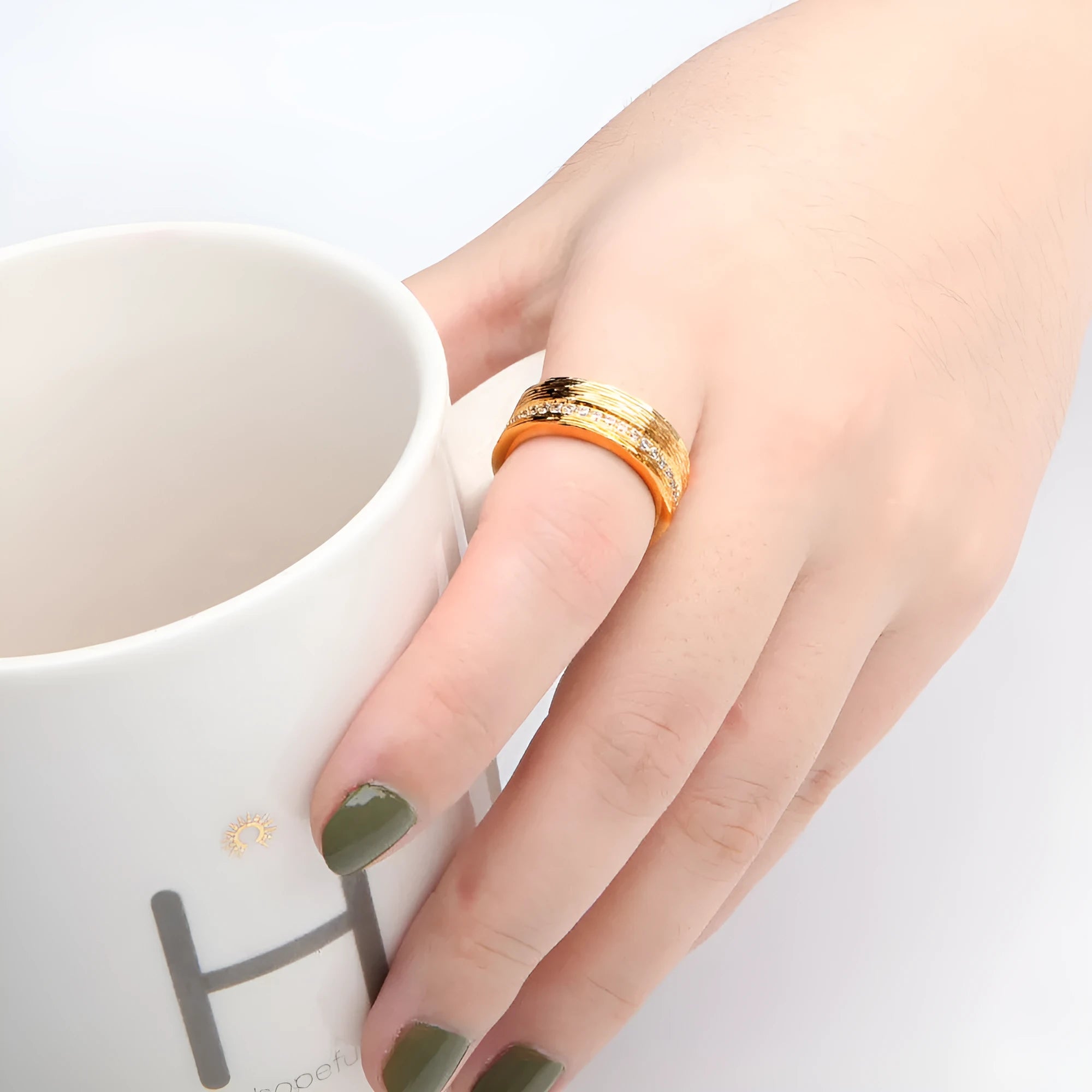 Geometric gold-coloured zircon ring for women on a plain background.