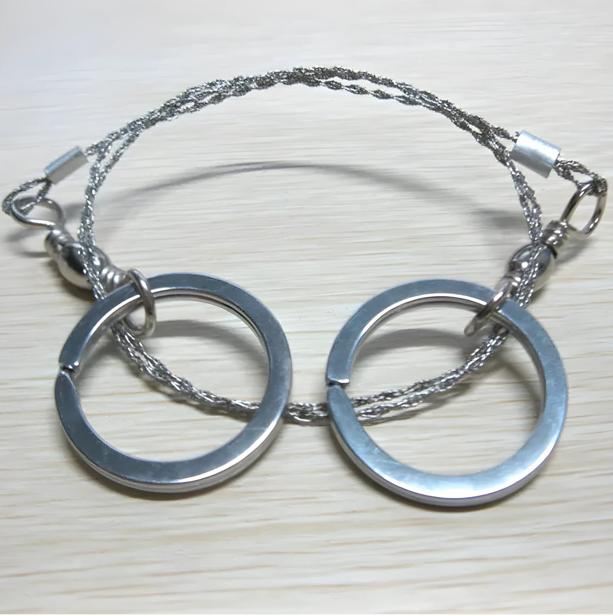 Stainless steel survival wire saw with thumb rings, showing extended length of 70cm.
