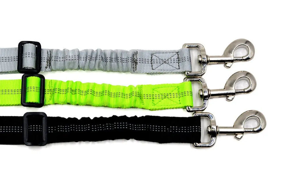 Black adjustable dog seat belt with reflective safety rope attached to car seat belt buckle, polyester webbing and alloy joint visible
