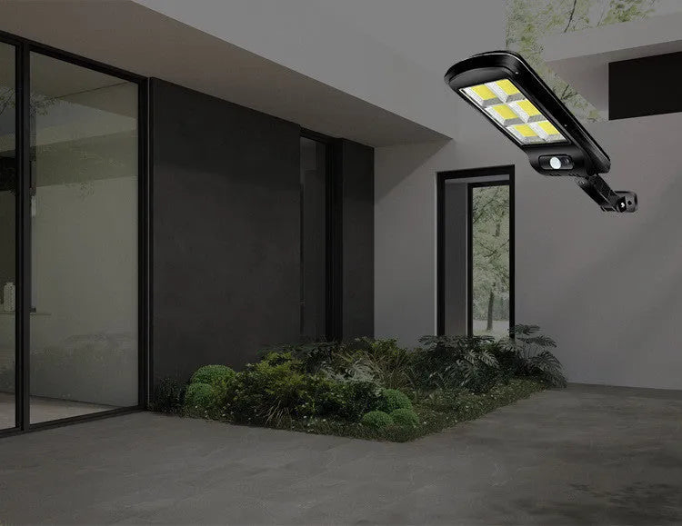 Black solar-powered outdoor motion sensor light mounted on a wall.
