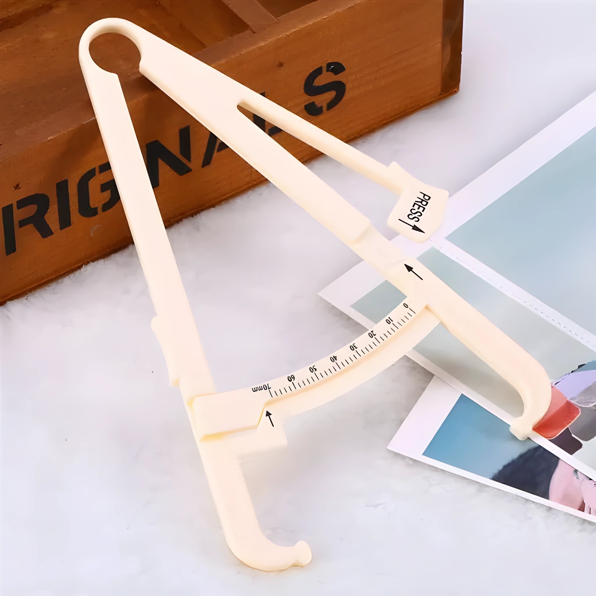 Compact acrylic body fat caliper showing measurement scale up to 200mm on a white background.