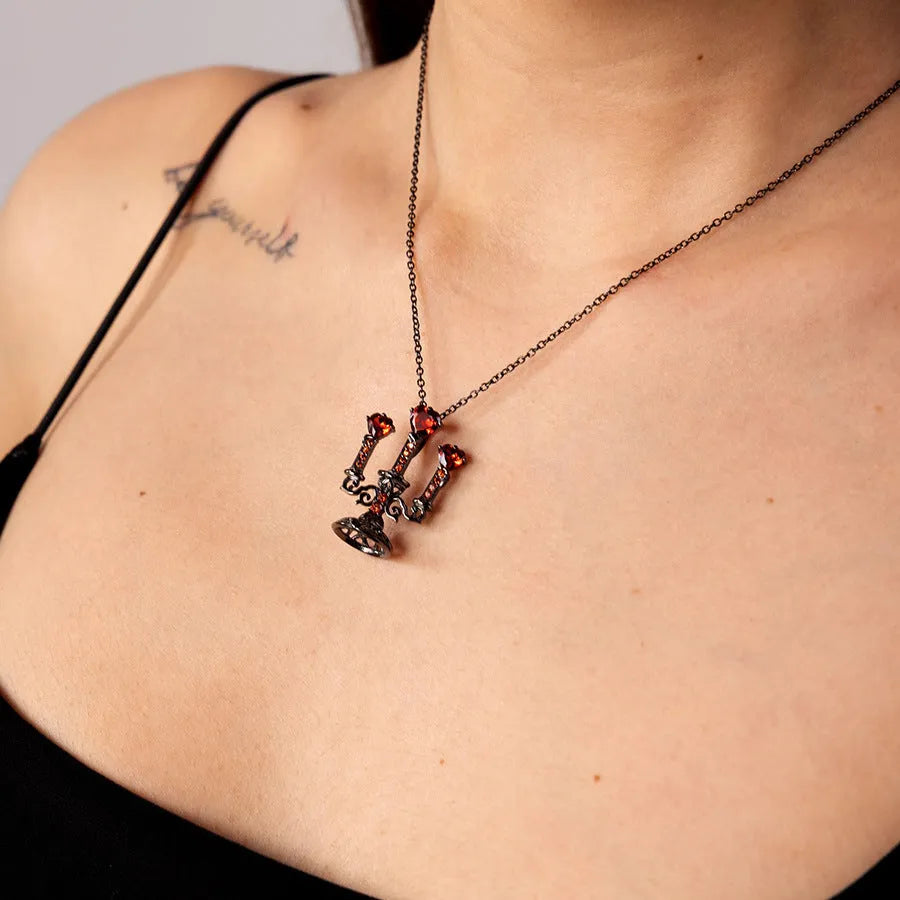 Women's silver Gothic necklace featuring a hollow candlestick pendant on a cross chain.
