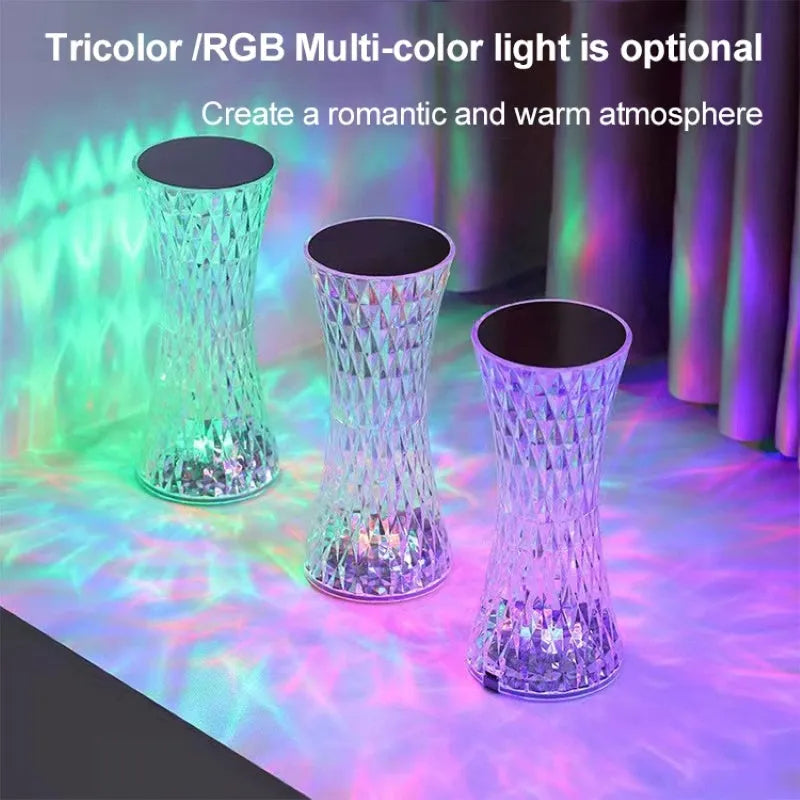 Transparent vase-shaped crystal LED table lamp on a table, showing soft coloured light.