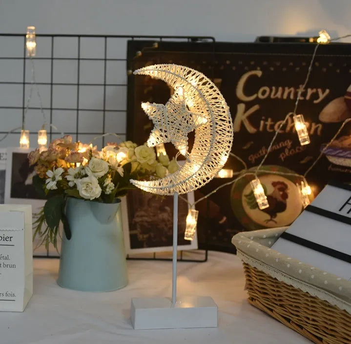 Rattan woven star-shaped LED table lamp with copper wire details on a table.