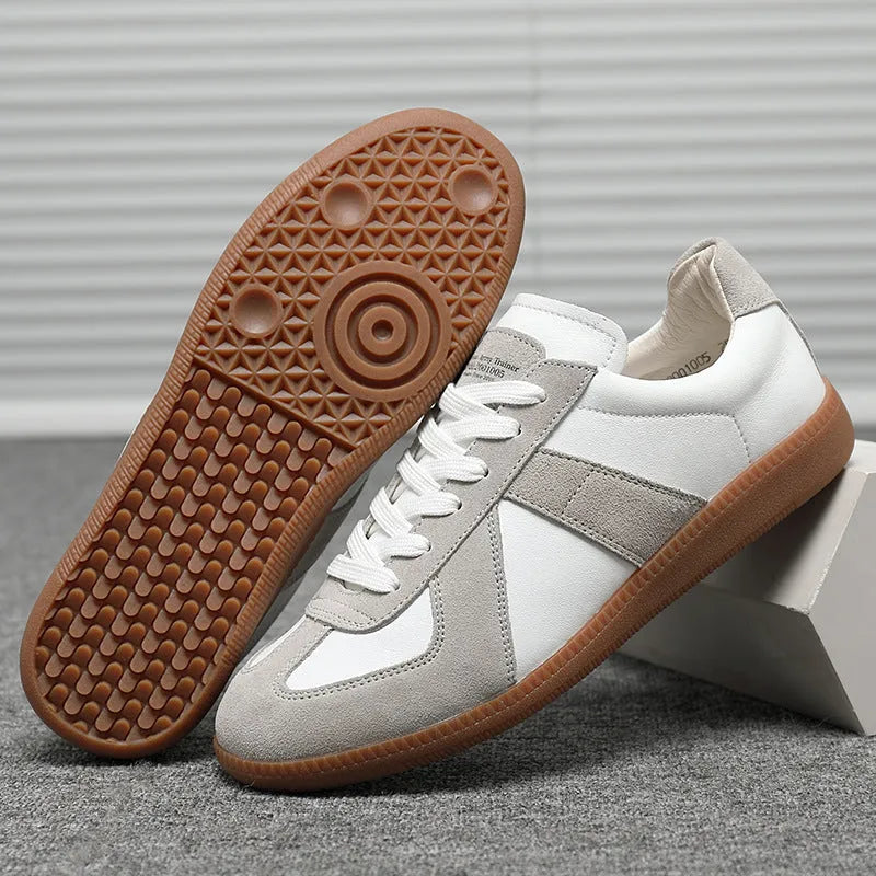 White Japanese-style retro low-top sneakers with round toe and flat rubber sole on a solid background.