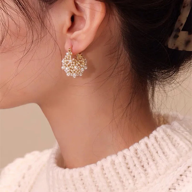 Gold-coloured copper flower basket earrings with small pearl-inlaid beads.