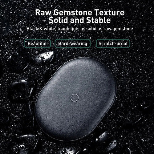 Black Baseus wireless charging pad with a textured surface and a small LED light, next to a mobile phone.