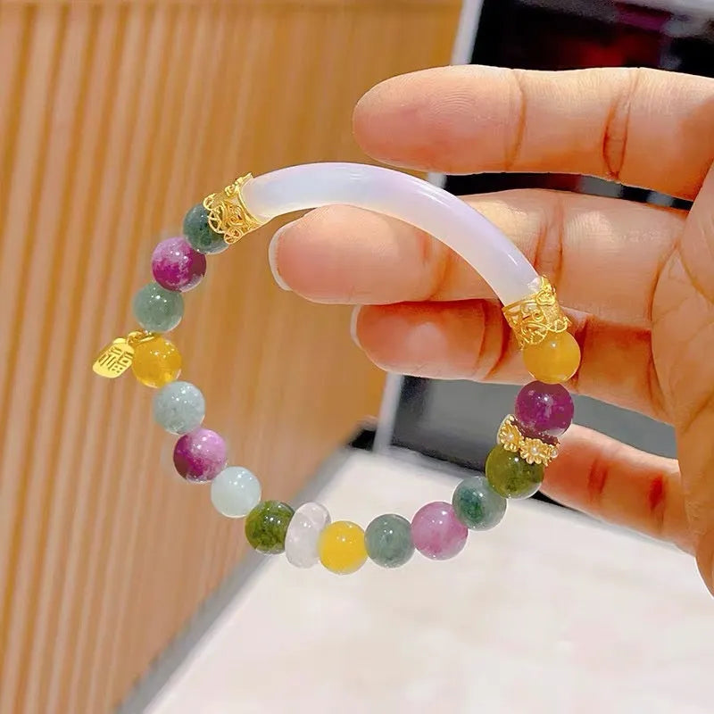 Natural rainbow-coloured tourmaline and jade half bracelet for women on a wrist.