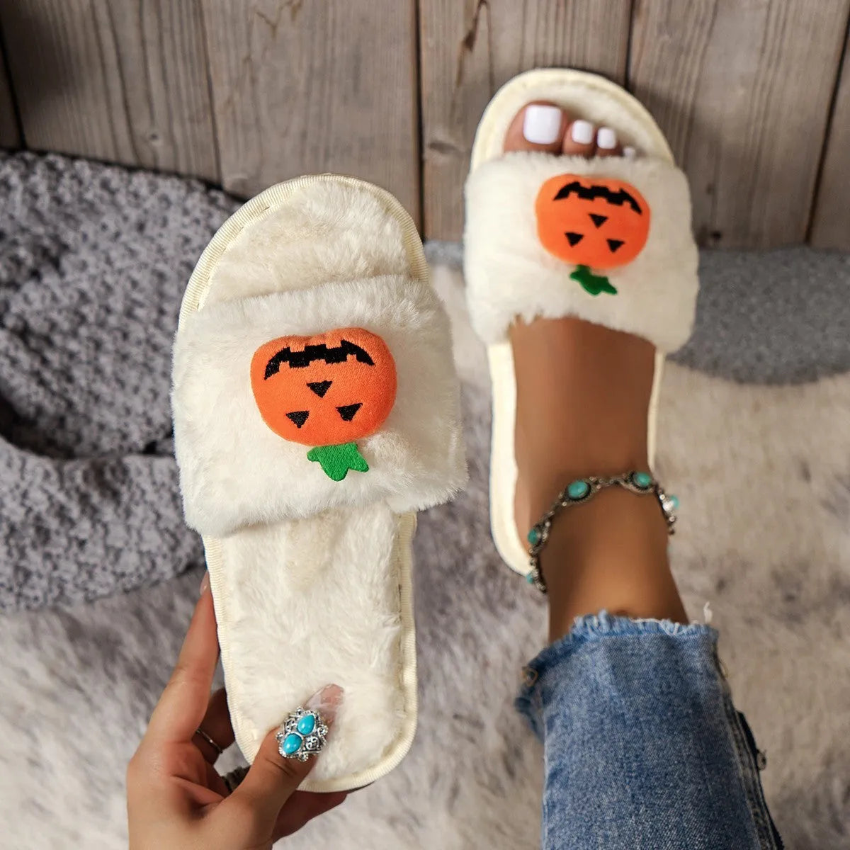 Yellow cartoon pumpkin plush slippers with open toe and anti-slip sole on a white background.