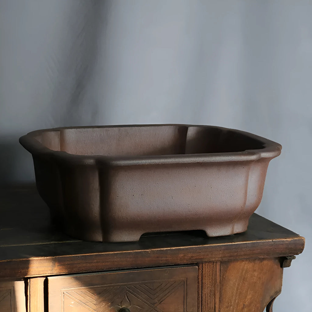 Purple sand rectangular ceramic bonsai pot on a flat surface.
