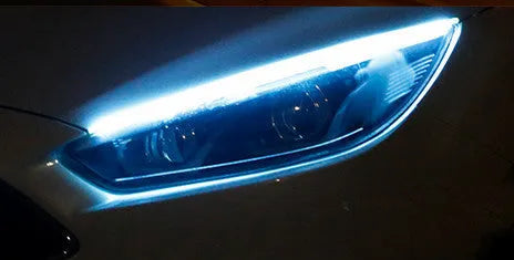 Slim silicone car LED daytime running light strip with flowing turn signal effect on a vehicle headlight.