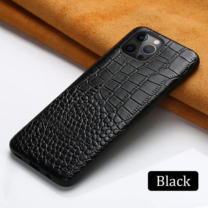 Handmade black leather iPhone case with a crocodile pattern texture on a table.
