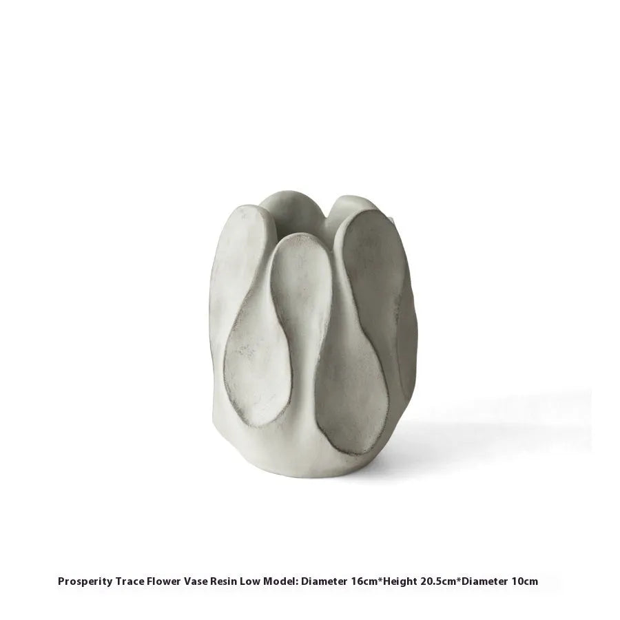 Irregularly shaped art ceramic vase in a low style profile on a wooden surface