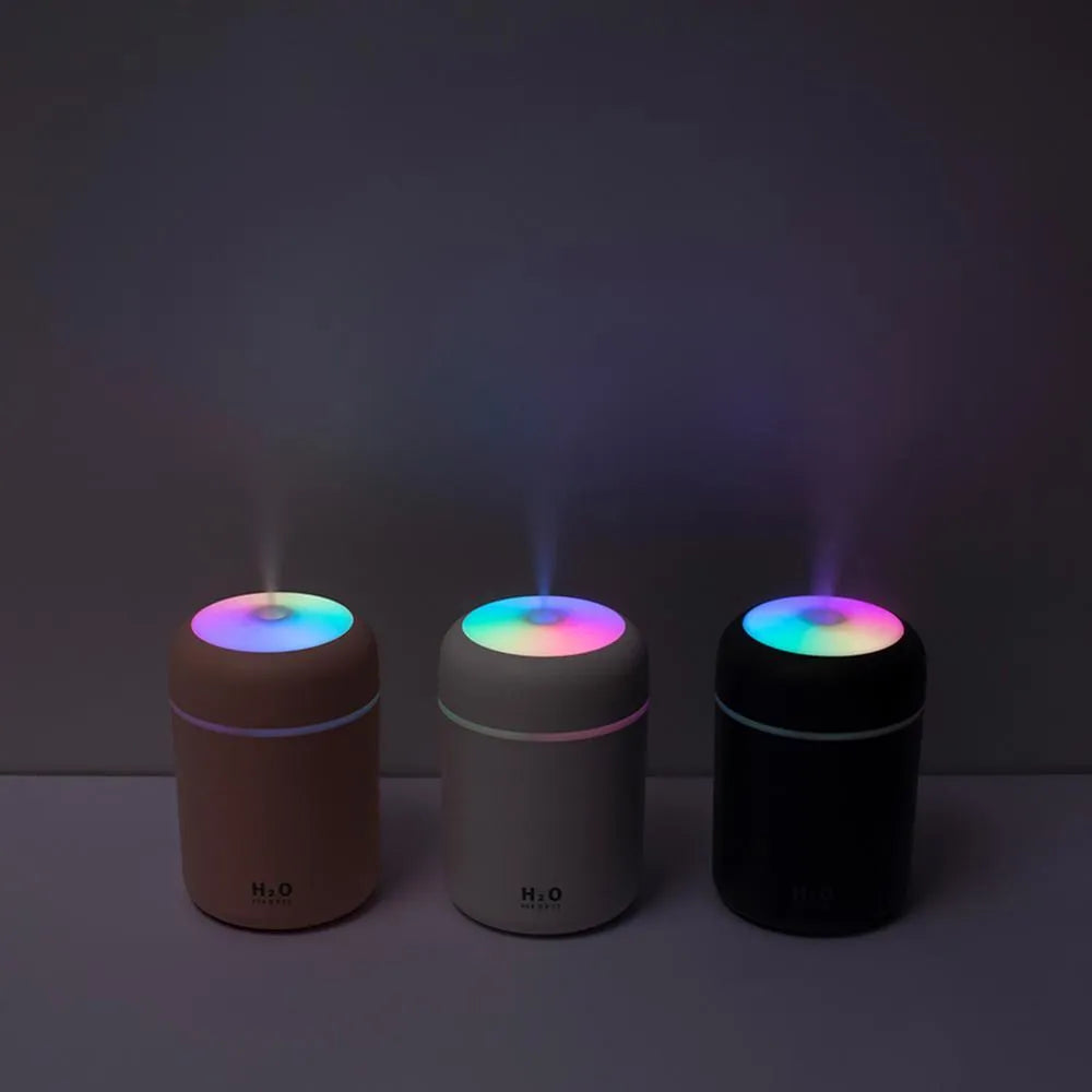 Pink USB desktop humidifier with colourful lights and 300ml water tank on wooden surface