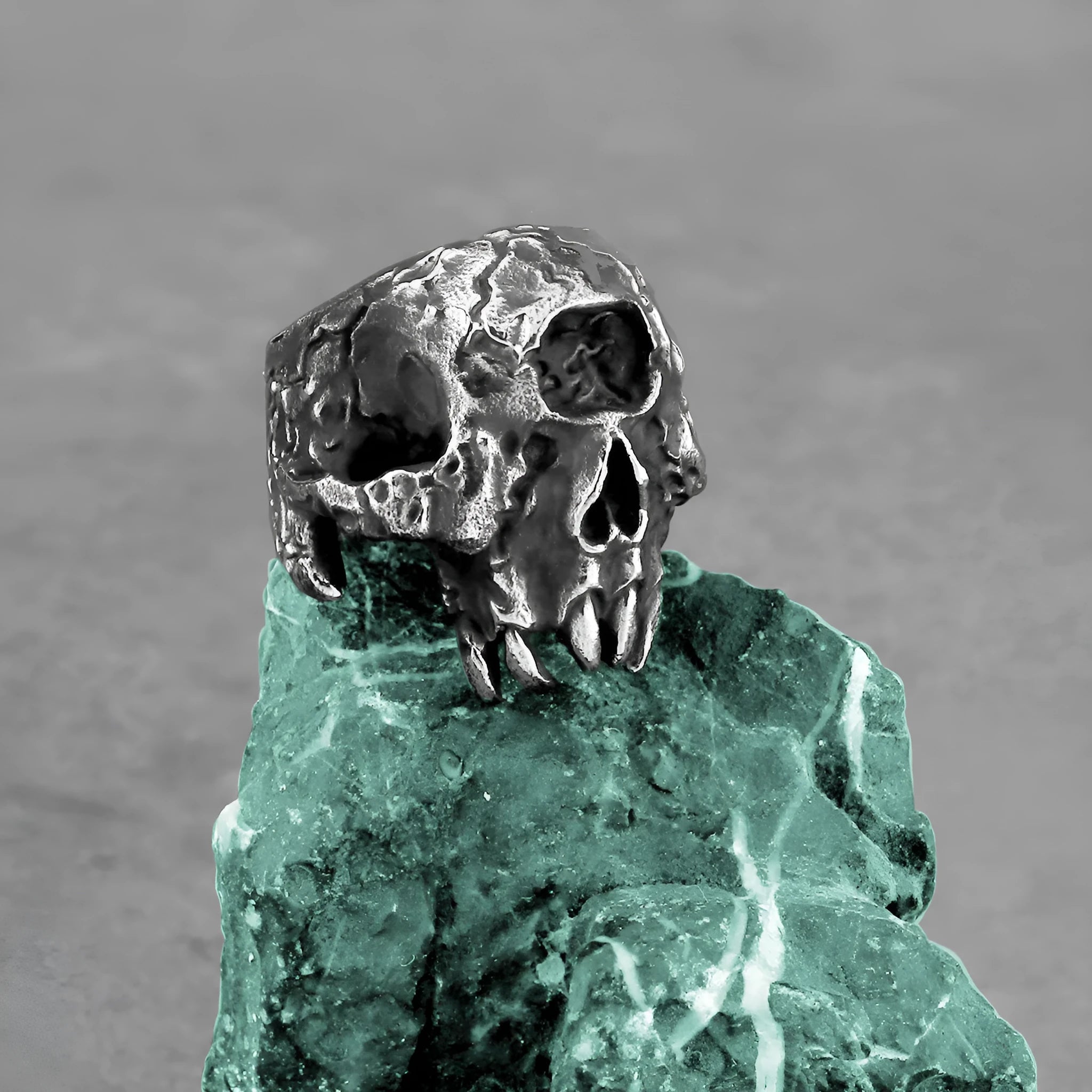 Silver-coloured alloy ring with a detailed one-eyed skull design on a finger.