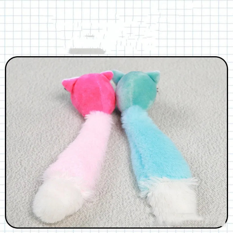 Three plush toy mice in green, pink, and blue with long tails, arranged on a surface