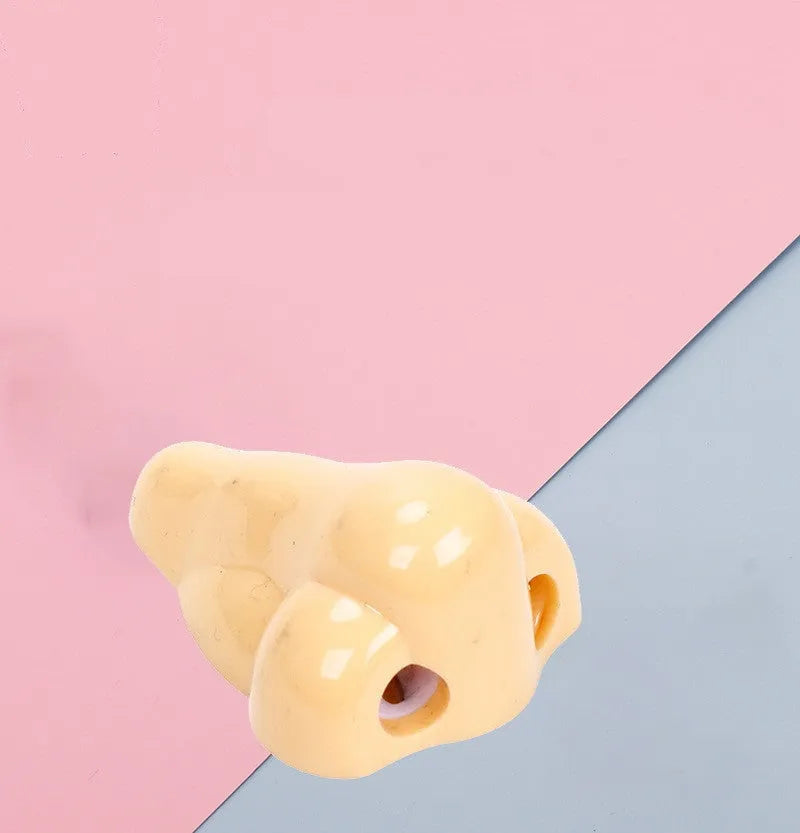 Flesh-colour plastic manual pencil sharpener with a large nostril and geometry-shaped body.
