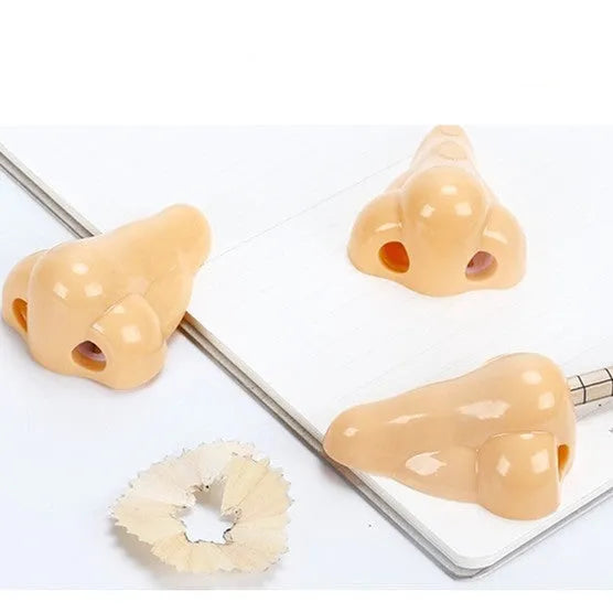 Flesh-colour plastic manual pencil sharpener with a large nostril and geometry-shaped body.