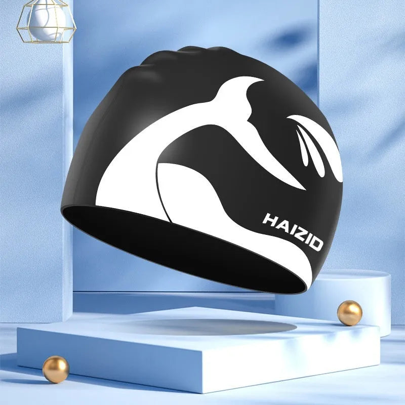 Silicone swimming cap with ear protectors in whale tail pattern, shown in black, blue, pink, and grey.