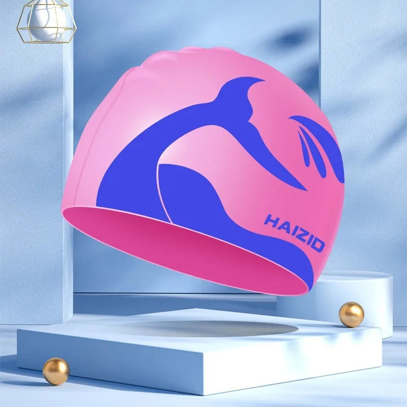 Silicone swimming cap with ear protectors in whale tail pattern, shown in black, blue, pink, and grey.