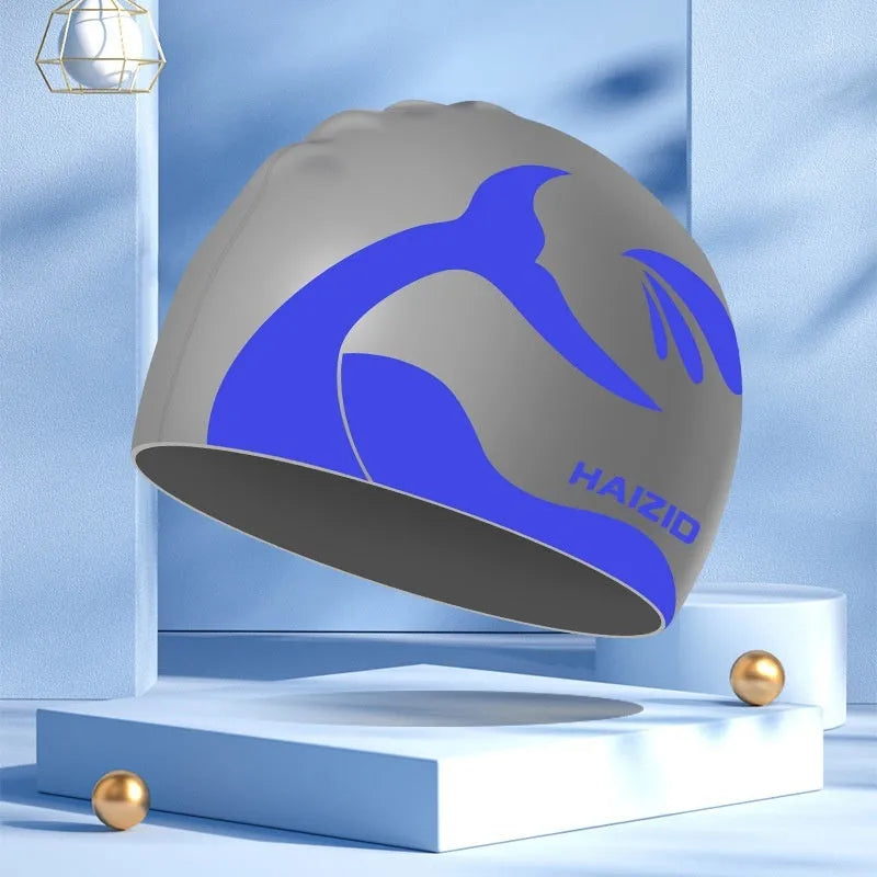 Silicone swimming cap with ear protectors in whale tail pattern, shown in black, blue, pink, and grey.