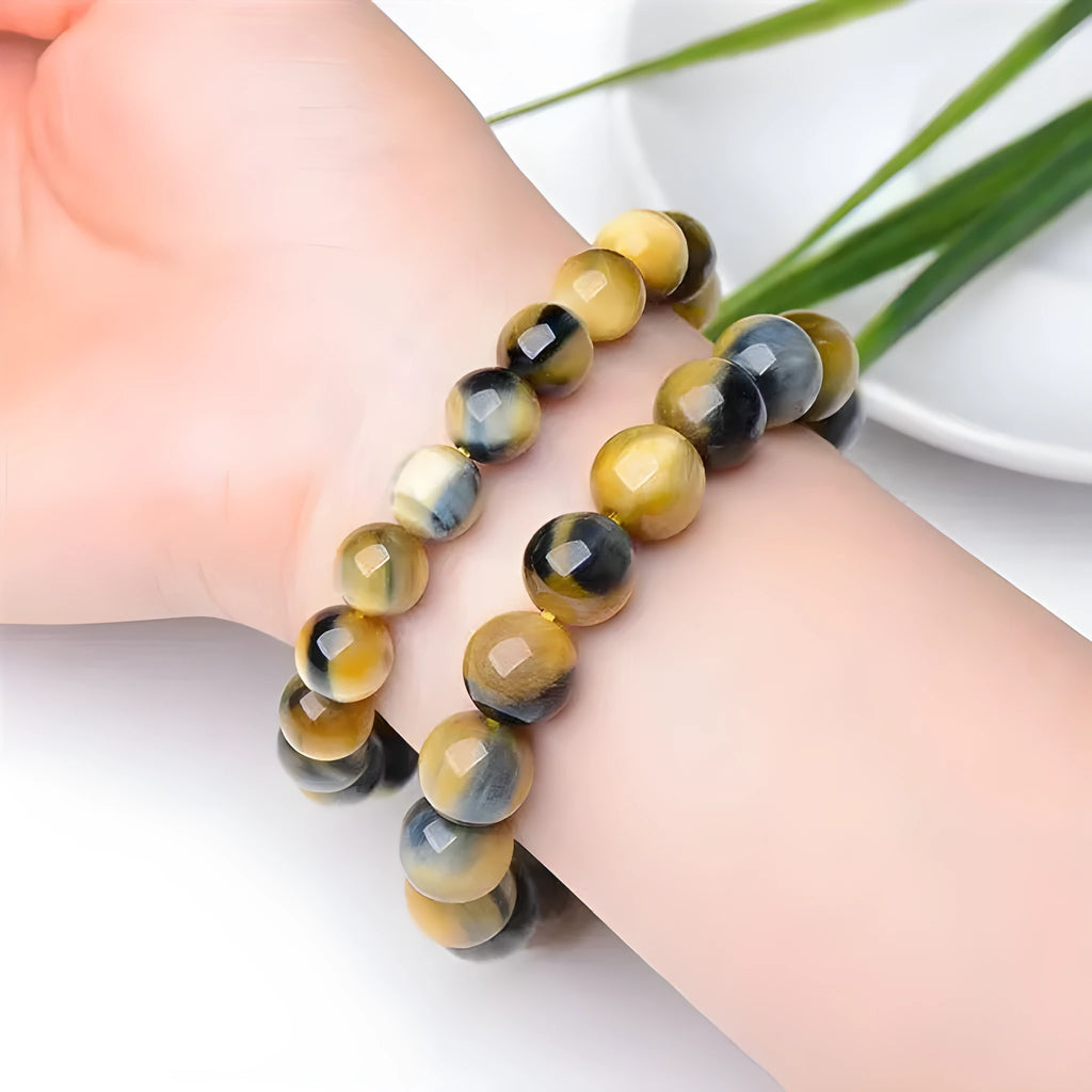 Handmade fantasy tiger eye agate bracelet with round beads on a neutral background.