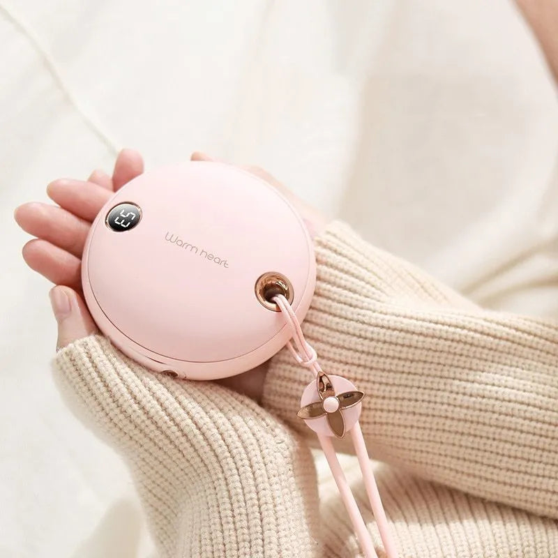 Green, pink, or white hand warmer power bank with digital display showing charge level