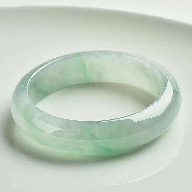 Light green jade bracelet on wrist, natural style, showing sizing scale from 53mm to 64mm