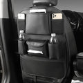 Leather car seat back storage bag hanging from vehicle headrest with multiple compartments