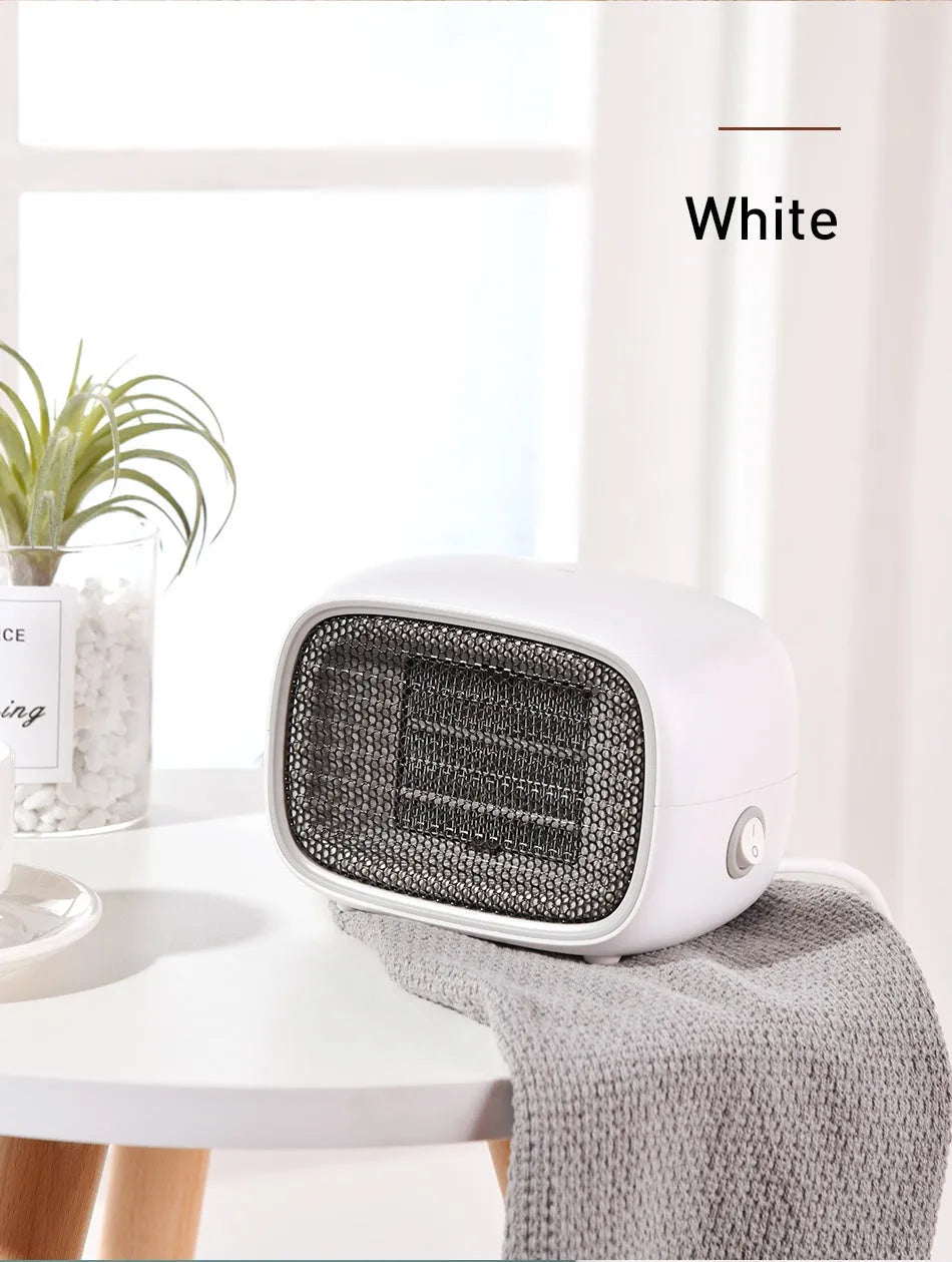 Green mini PTC ceramic heater showing compact size and metal mesh grille.