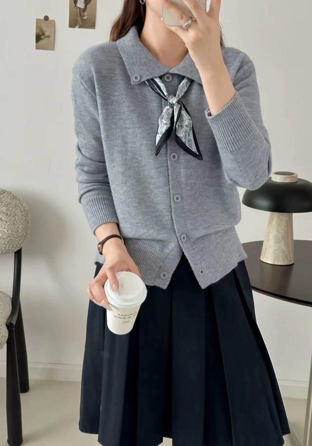 Beige lapel scarf cardigan sweater with long sleeves and splicing detail on a hanger.