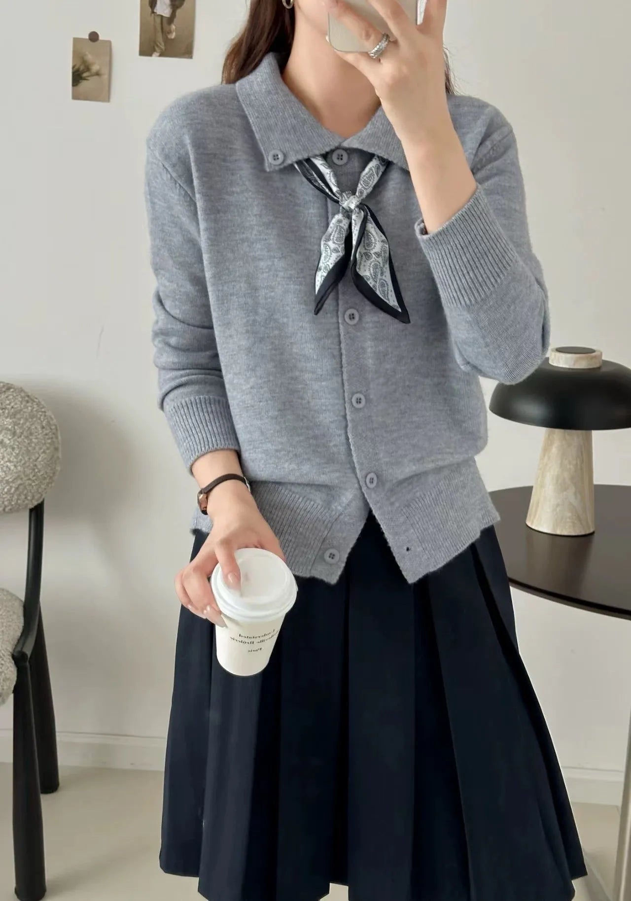 Beige lapel scarf cardigan sweater with long sleeves and splicing detail on a hanger.
