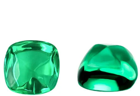 Selection of cultivated Columbia green emerald gemstones in various shapes and sizes on a white background.