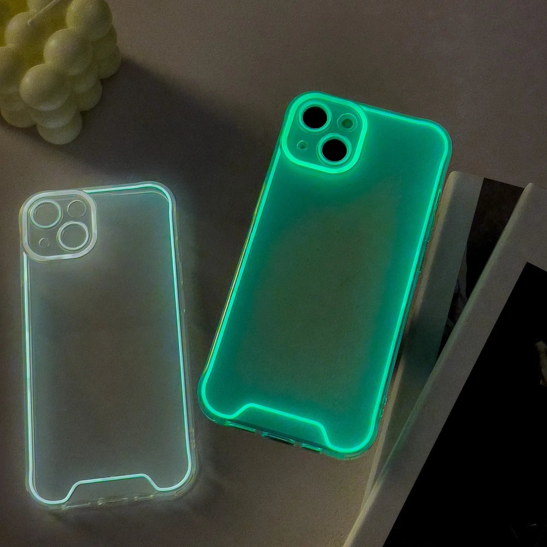 Glow in the dark green soft TPU phone case for iPhone on a dark background.