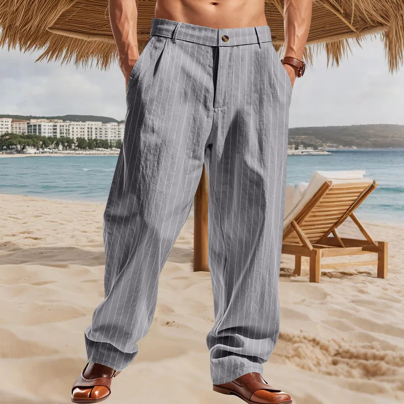 Man wearing straight-cut, high-waisted linen trousers with a wide leg and striped pattern in a light colour.