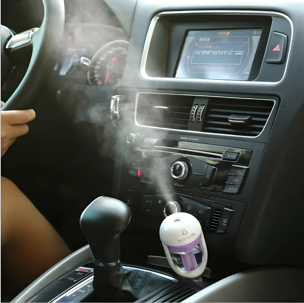 Compact blue car humidifier with rotating nozzle in vehicle cup holder
