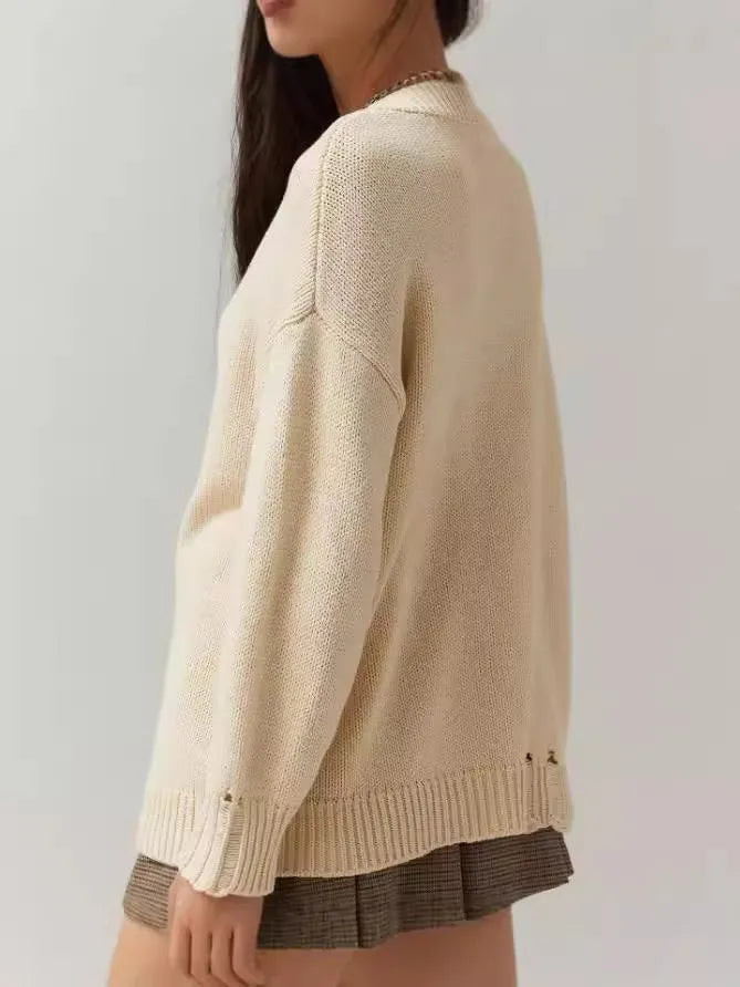 Women's milky white round neck jacquard knit acrylic sweater on a hanger.