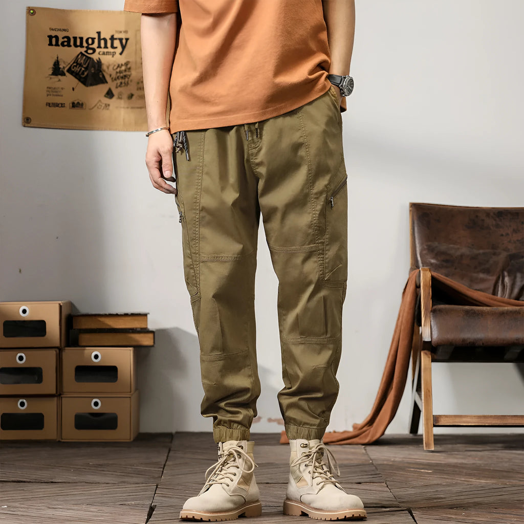 Man wearing khaki-coloured loose cotton harem trousers with a tapered ankle band.