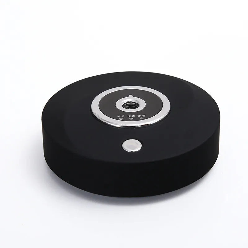 White plastic car aromatherapy diffuser with USB cable and anti-slip pad on a car dashboard.