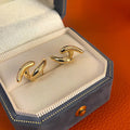 Women's textured line geometric copper stud earrings in silver and gold tones on neutral background