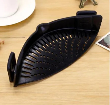 Silicone clip-on kitchen strainer with stainless steel filter mesh attached to a pot rim