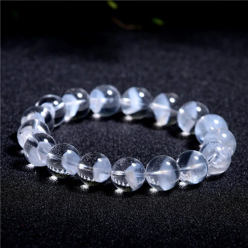 Women's adjustable white crystal ghost pyramid bracelet with Ruyi charm on wrist.