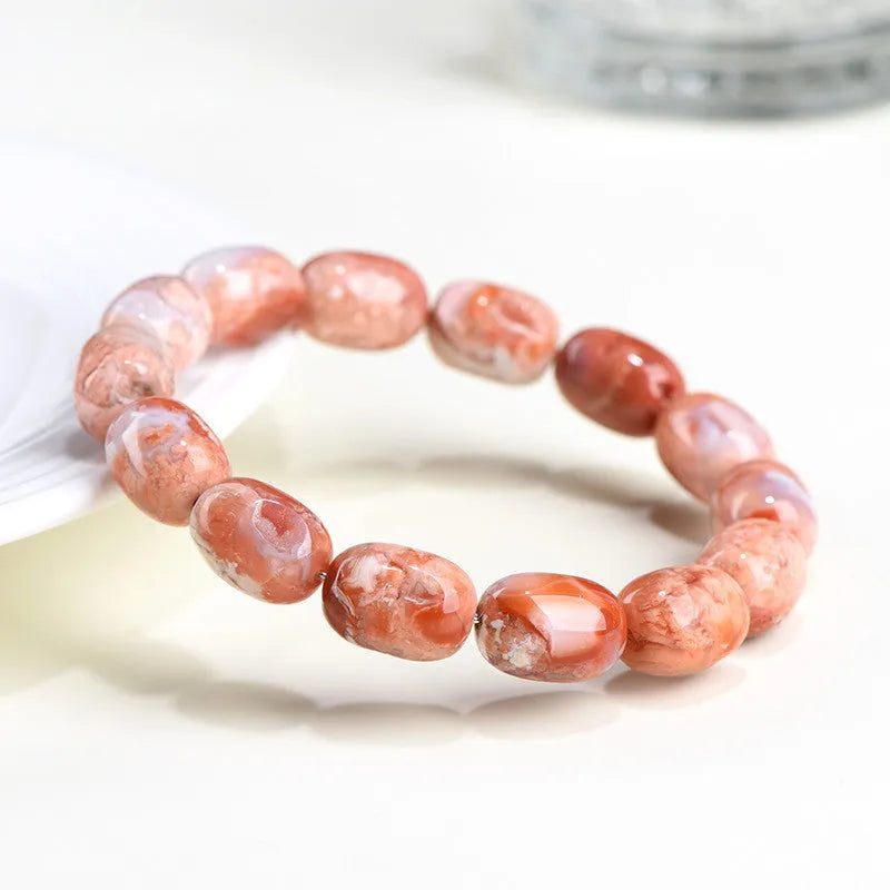 Natural cherry agate bracelet with 10x14mm barrel beads and a geometric ruyi design.
