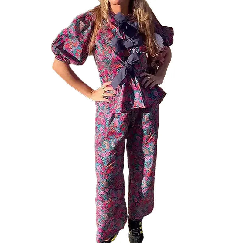 Women's floral print trousers suit with a tie-neck puff sleeve top and matching trousers