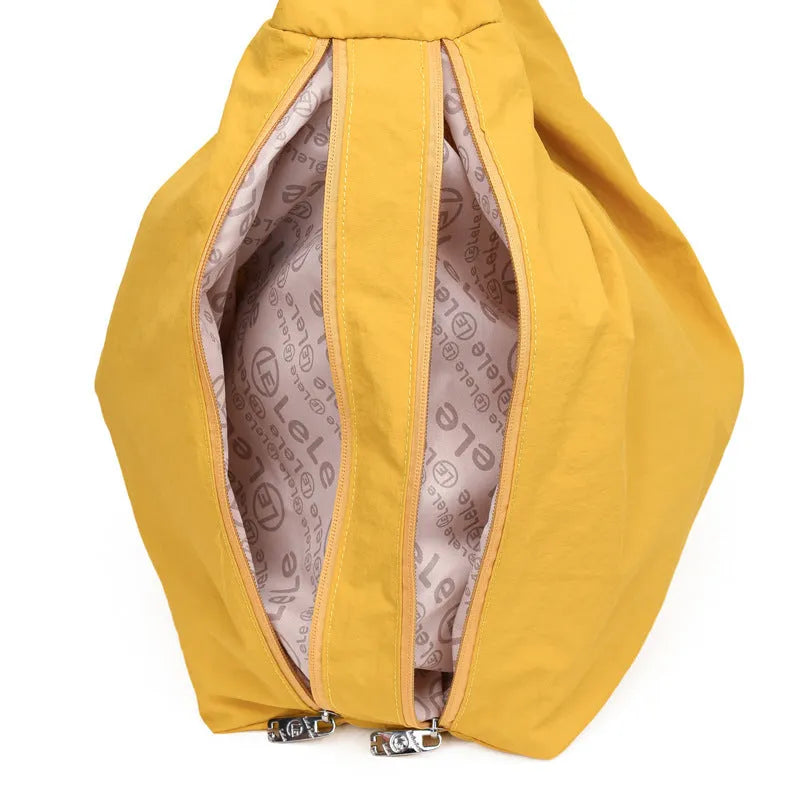 Soft heart-shaped nylon underarm bag for women in yellow, shown worn crossbody.