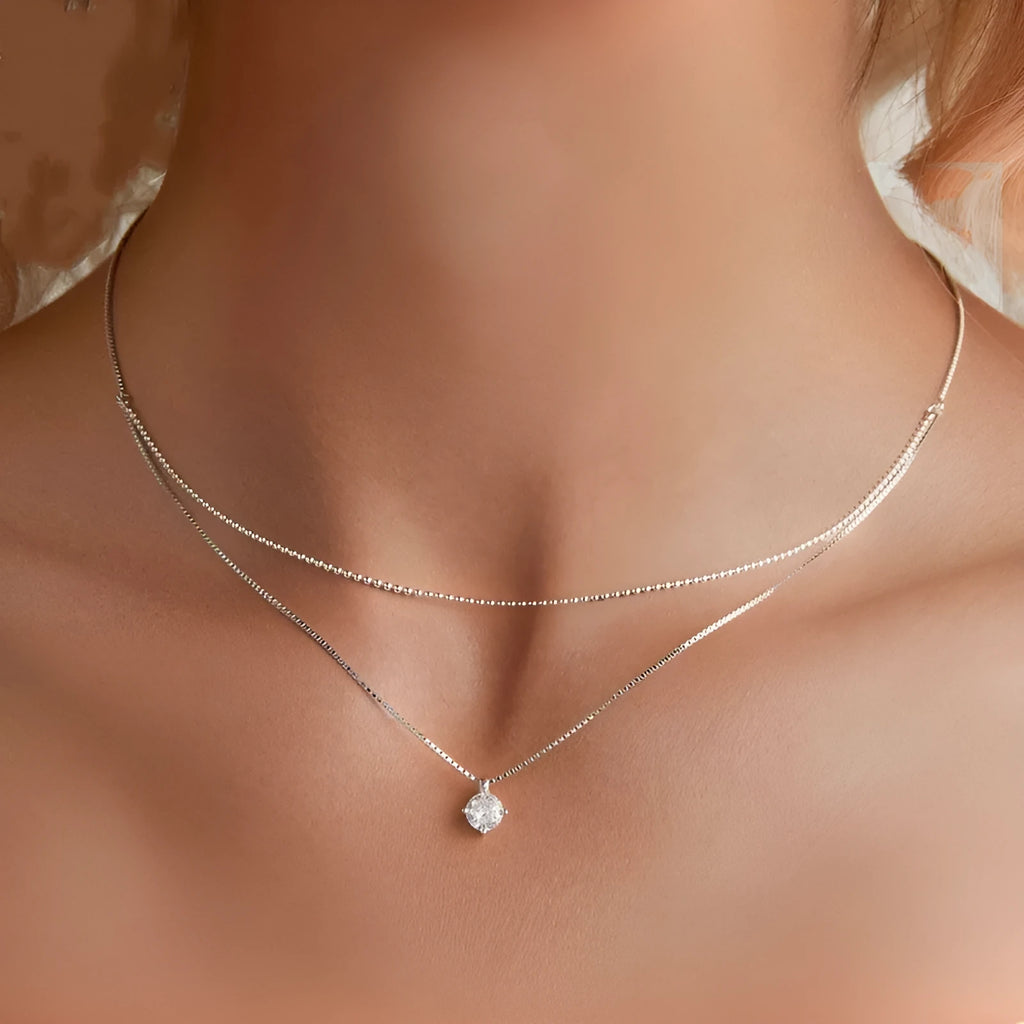 Close-up of a women's double-layer pearl chain sterling silver necklace with a matching pendant.